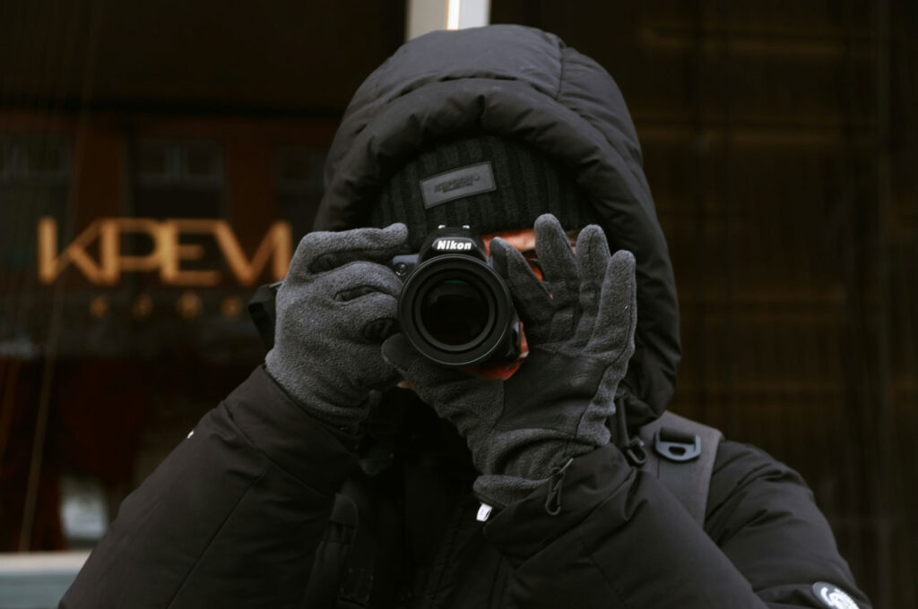 cameraman met winterjas, handschoenen en muts