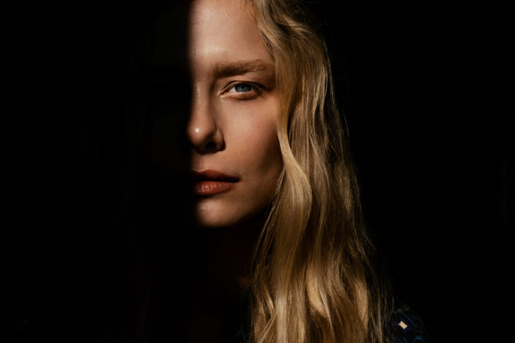 portretfoto van blond model half belicht, half schaduw