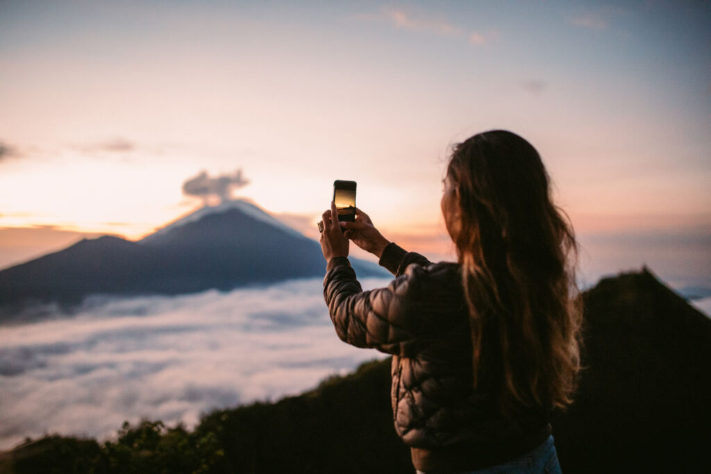 foto maken met smartphone van bergen bij zonsondergang