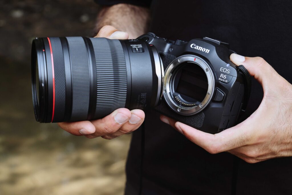 Canon EOS R6 III in handen van fotograaf met lensvatting zichtbaar