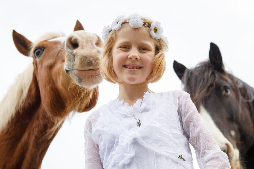 Portret van meisje met twee paarden communie