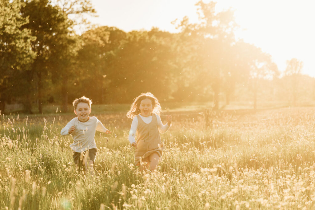 twee kindere lopen in de zon door de heide