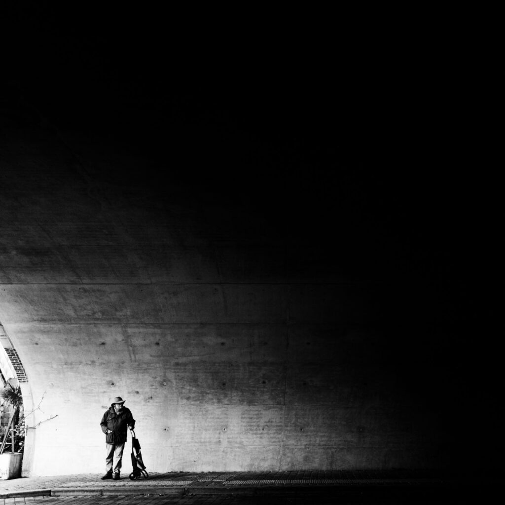 minimalistische straatfotografie zacht licht brug figuur negatieve ruimte zwart-wit compositie