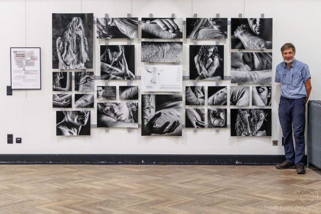 fotograaf Robert Biesemans voor een galeriewand met ingelijste foto's, auteur van het artikel over dpi en pixels