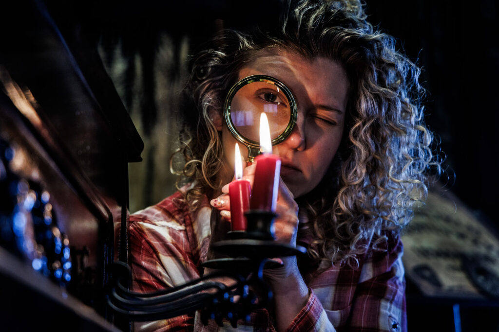 Modelfotografie in huis: model met vergrootglas bij kaarslicht over perfectionisme en autisme