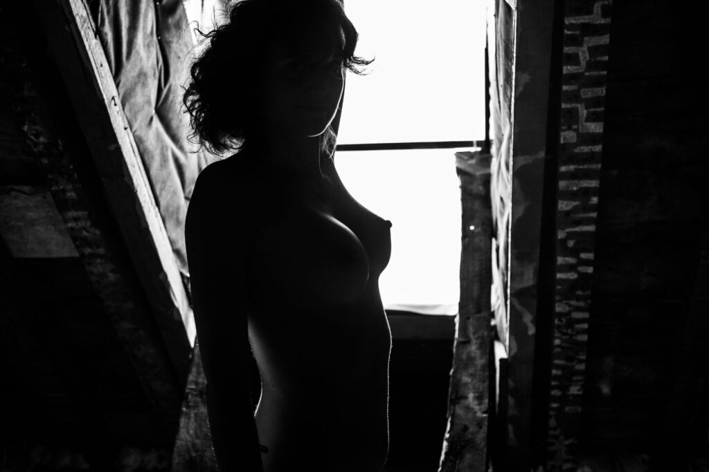 Modelfotografie in huis: silhouet van een model tegen verblindende zon door een dakvenster