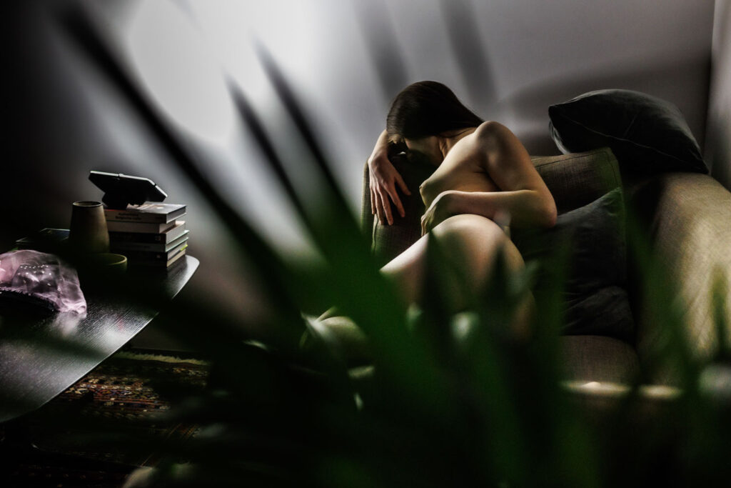 Modelfotografie in huis: naaktfoto gefotografeerd door een kamerplant met aanwezig licht