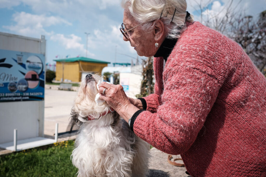 Spontaan reisportret van een oudere vrouw met haar hondje