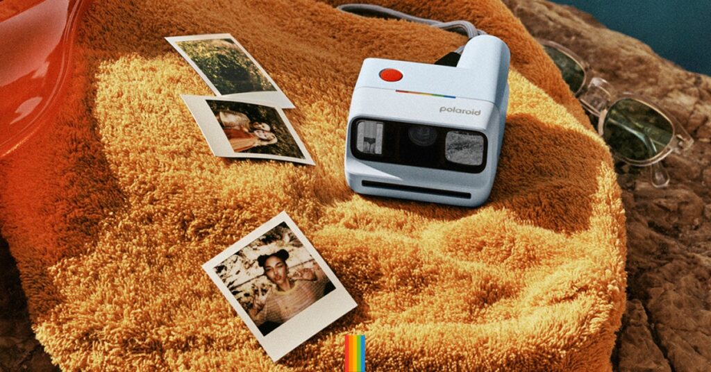 Polaroid Go Gen 3 op handdoek strand met enkele prints