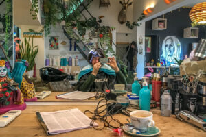 Portretfotografie met smartphone: fotograaf maakt een spiegelportret in een drukke kapper/koffiebar