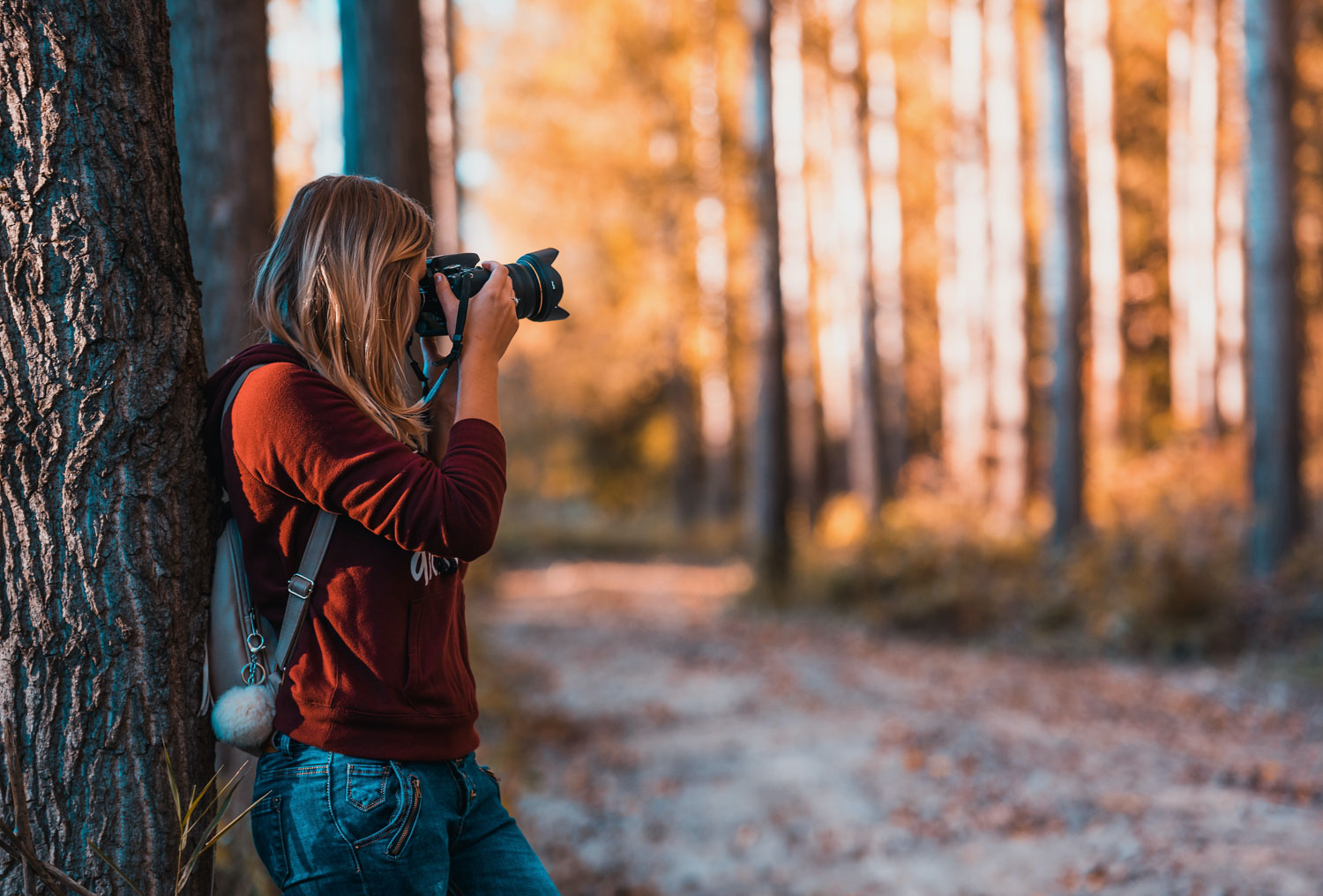 Fotografe houdt camera stevig vast in herfstbos om bewegingsonscherpte te vermijden