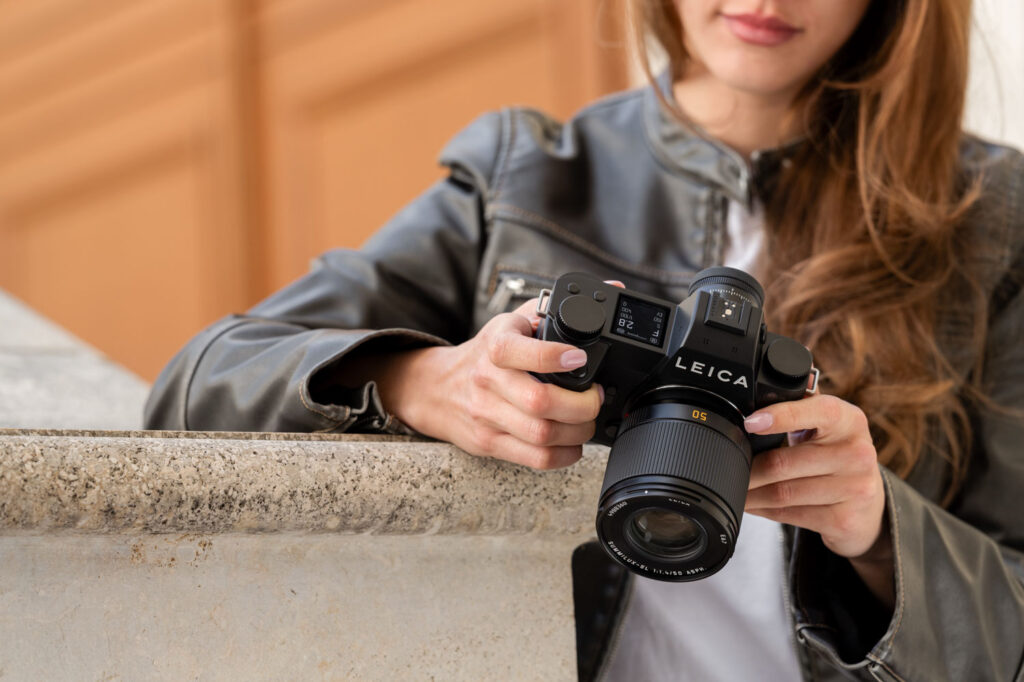 Leica SL3-P in handen van vrouwelijke fotograaf, vooraanzicht