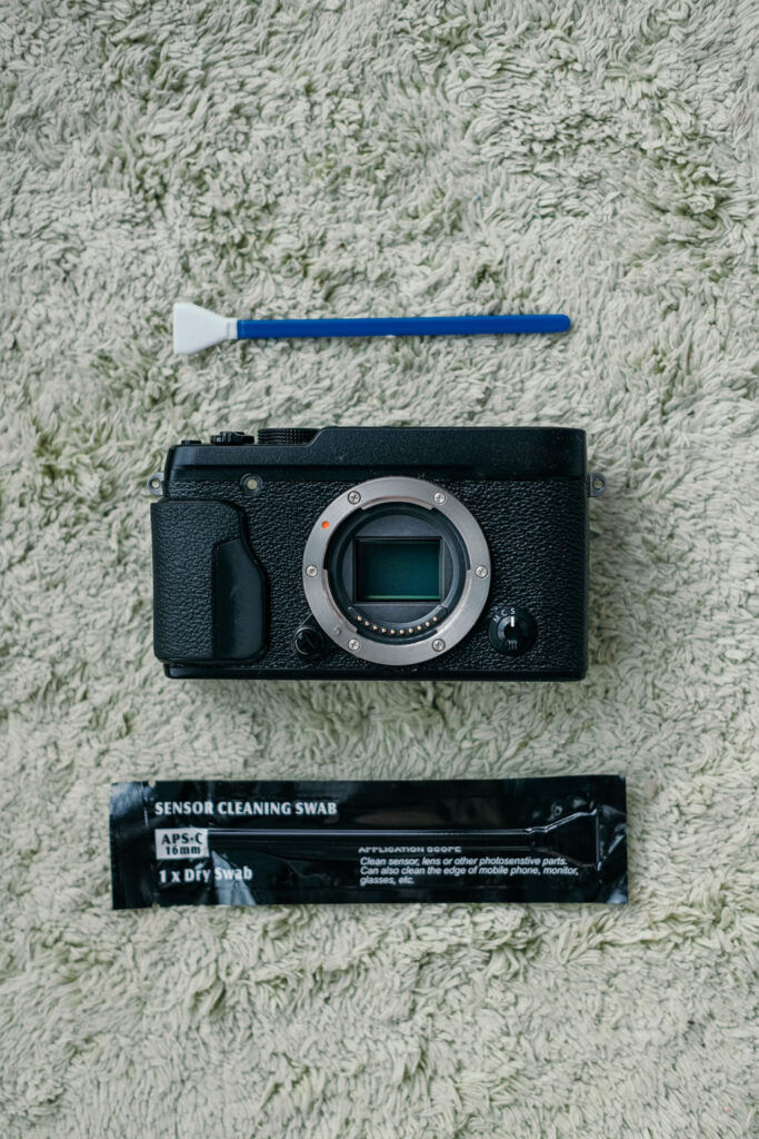 Cameralichaam met sensorreinigingsswab, beginnersfout in de fotografie: lens en sensor niet proper houden