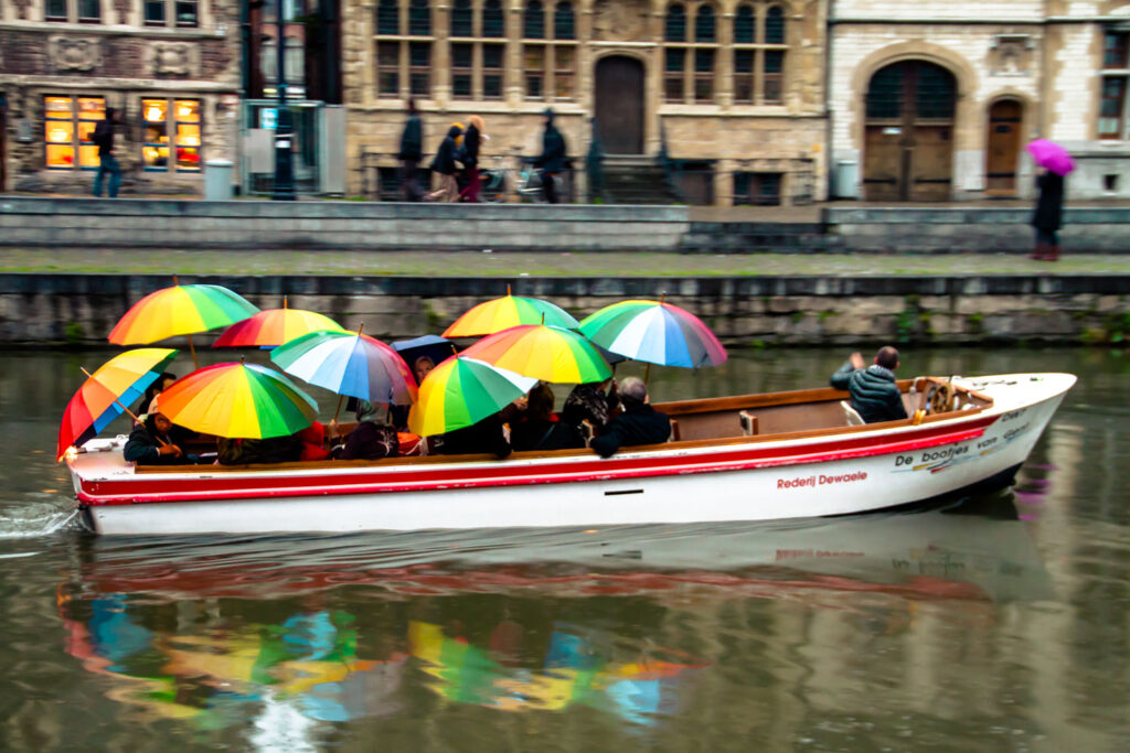 Kleurrijke boottocht met paraplu's op het water in Gent op een regendag, fotograferen in Gent bij regen