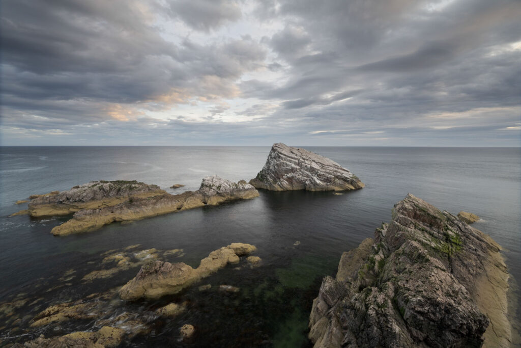 Onbewerkte landschapsfoto van rotsen in zee toont het effect van nabewerking