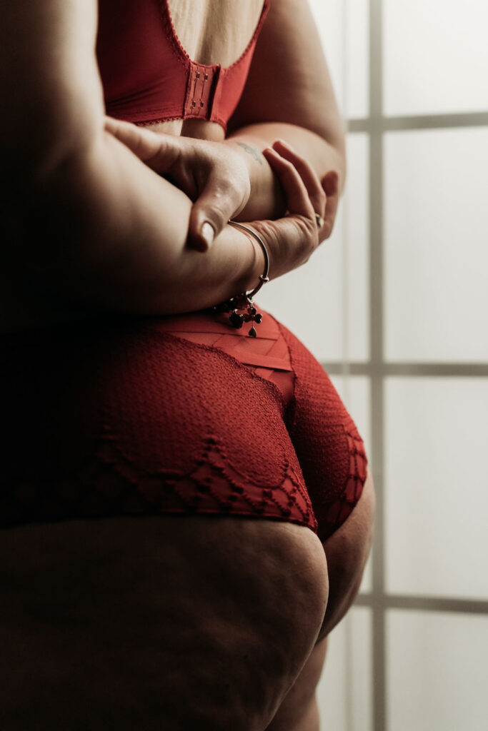 Authentieke boudoirfotografie van een vrouw in rode kanten lingerie