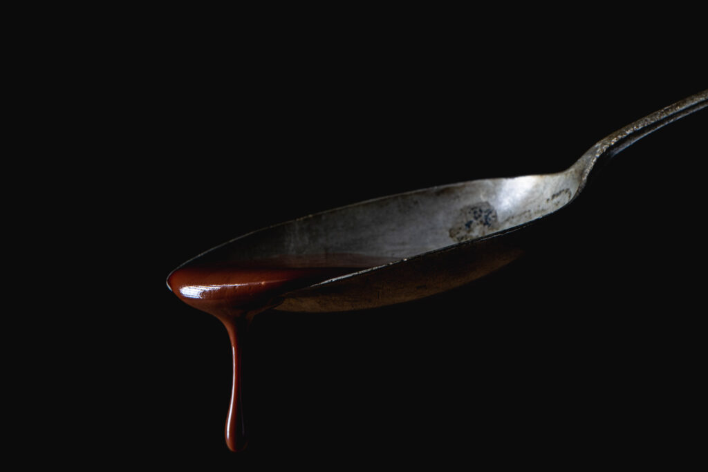 Macro foodfotografie van chocoladesaus die van een lepel valt en een verhaal vertelt