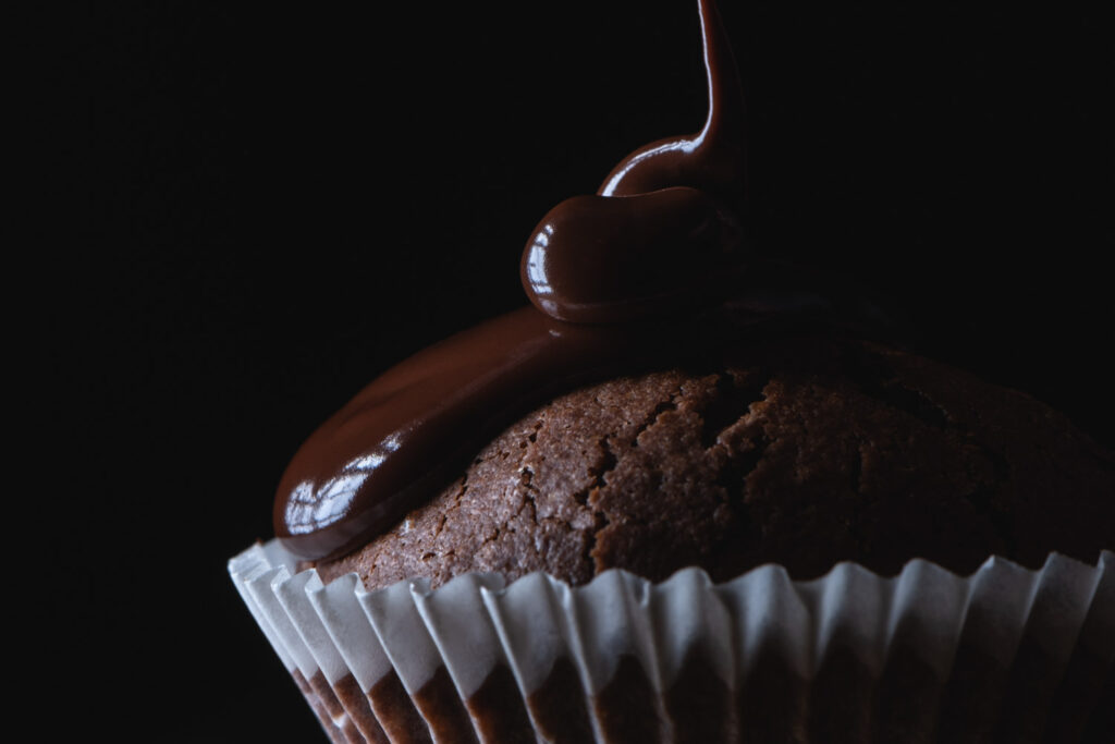 Macro foodfotografie van een chocoladecupcake met druipende saus