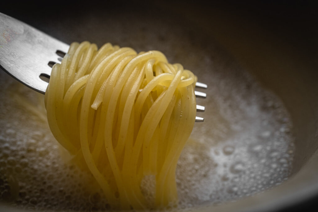 Macro foodfotografie van spaghetti op een vork met gericht licht