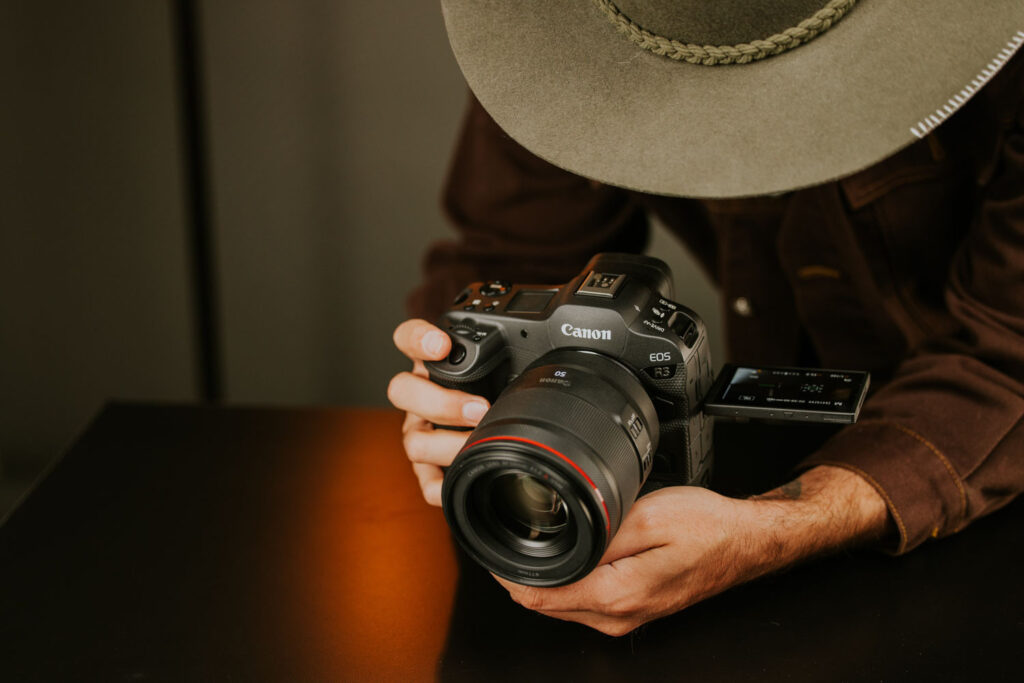 canon camera in handen fotograaf met hoed