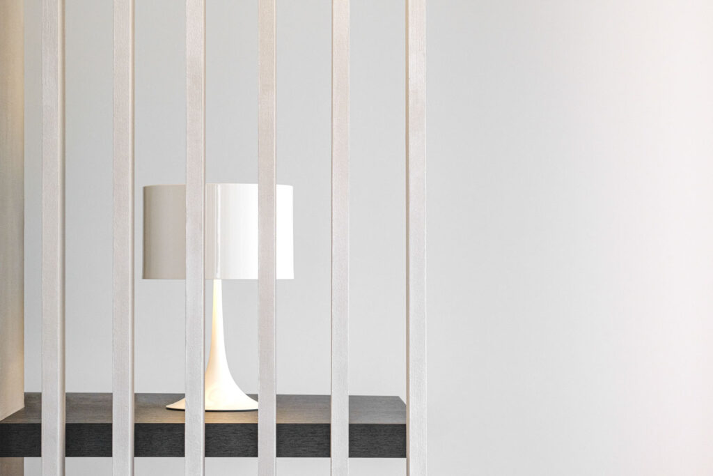Sfeerbeeld met een lamp onscherp achter een houten raster, meubels fotograferen
