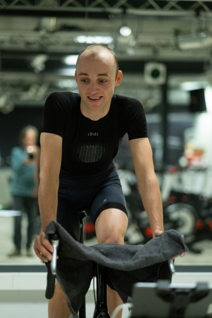 Wielrenner op hometrainer bij natuurlijk licht zonder reportageflitser