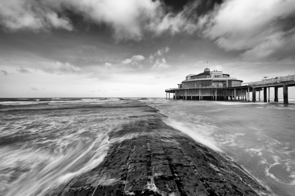 Slecht weer fotografie aan de kust met pier en ruw weer als ideale landschapslocatie
