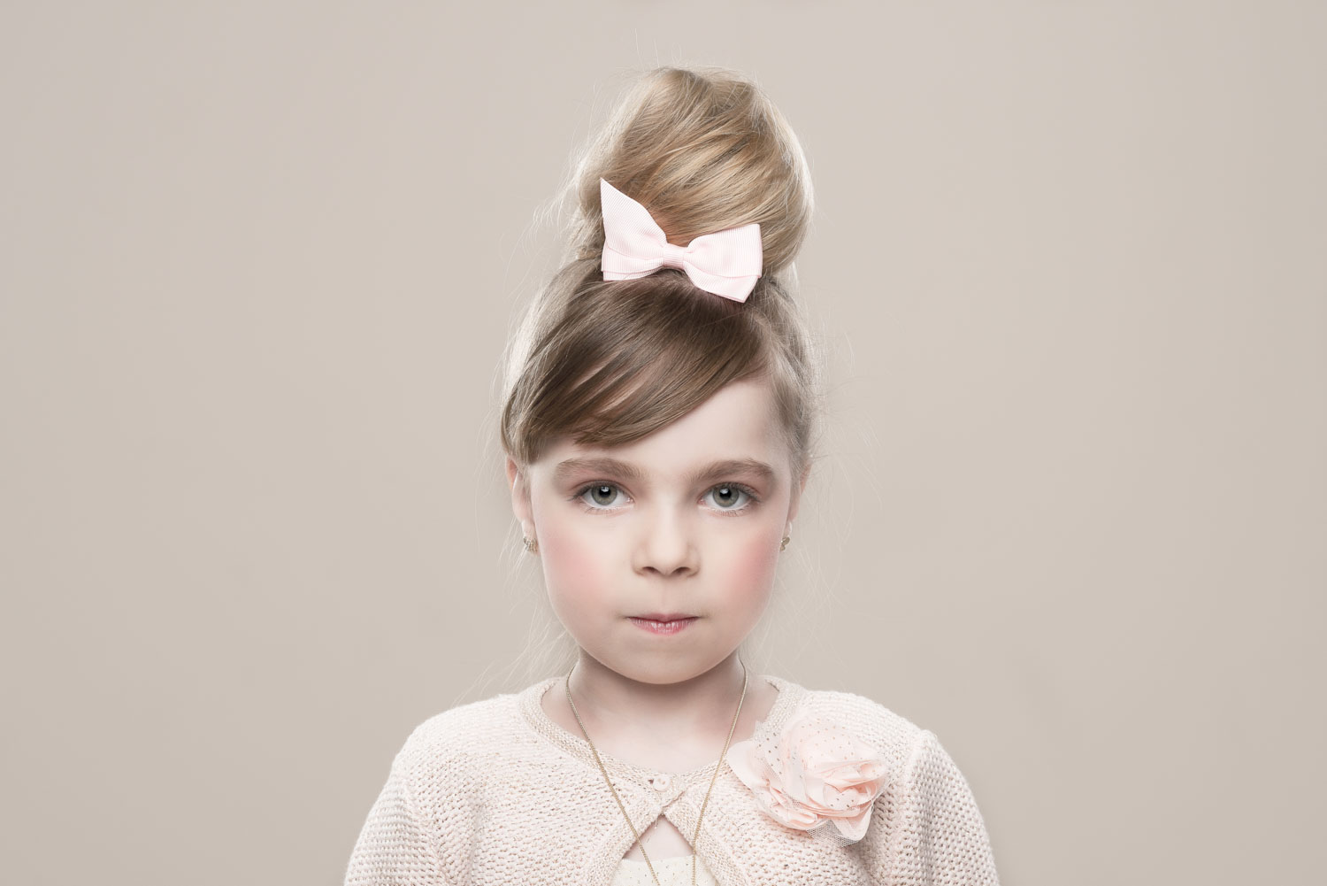 Jong meisje geportretteerd als levende porseleinen pop met lichte styling en haarstrik